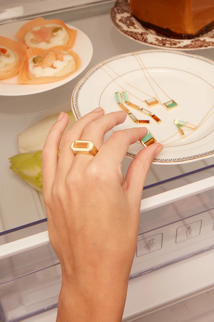 複数のストーンの金のリングを付けた女性の手
