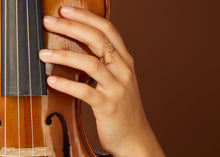 画像をギャラリービューアに読み込む, ダイヤモンドのついた恐竜の金のリングをつけた女性の手