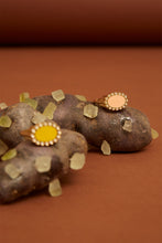 画像をギャラリービューアに読み込む, 複数の天然石のついた18金の指輪がおかれている