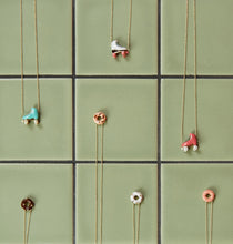 画像をギャラリービューアに読み込む, 複数のドーナッツとローラースケートの金のネックレスがおかれている