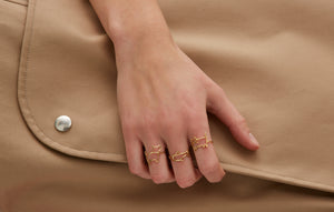複数の種類の金のリングをつけた女性の手