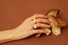 画像をギャラリービューアに読み込む, 複数の天然石のついた18金のリングをつけた女性の手
