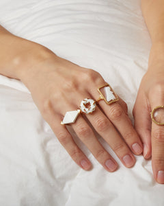 複数の種類の金のリングをつけた女性の手